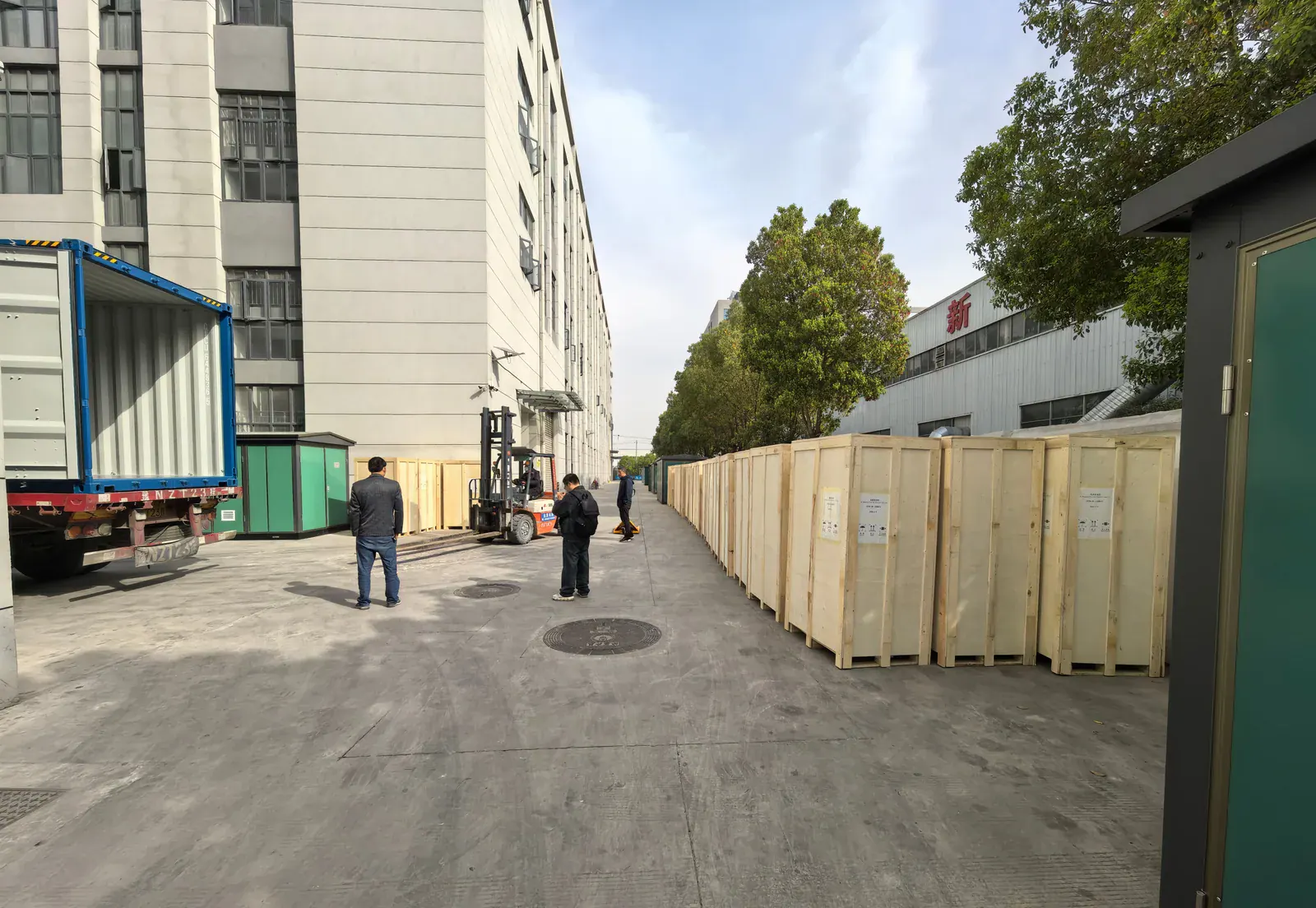 Batch of timber cases containing EV charging equipment staged beside a container truck